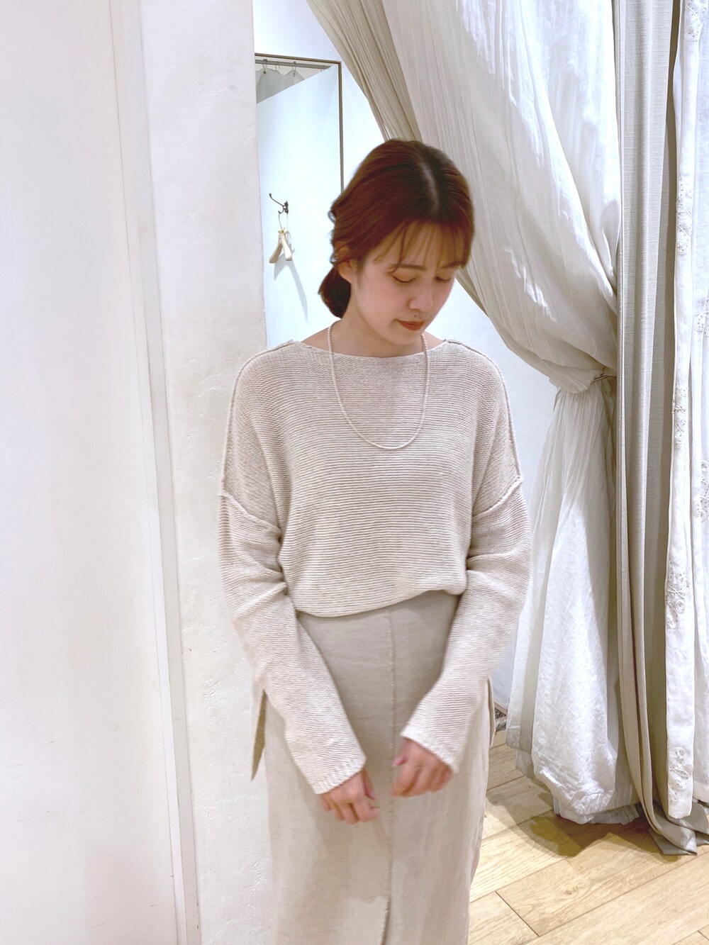 ベージュ系のニット/セーター、ベージュ系のスカート、ベージュ系のサンダルを着用したレディースの春コーディネートの2枚目の写真