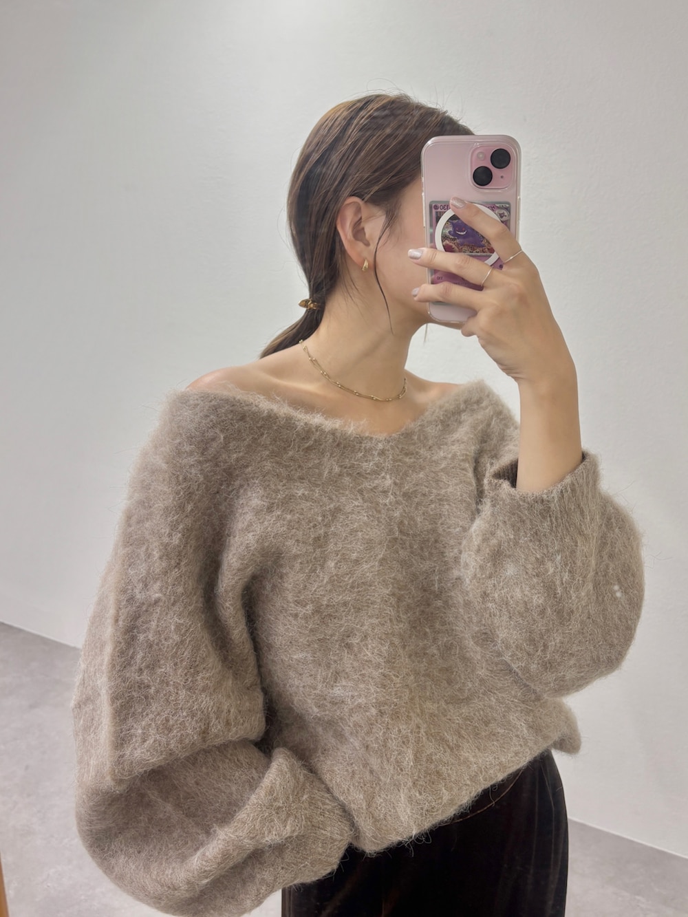 ブラウン系のニット/セーター、ブラック系のトートバッグ、ブラウン系のスカートを着用したレディースの秋コーディネートの3枚目の写真