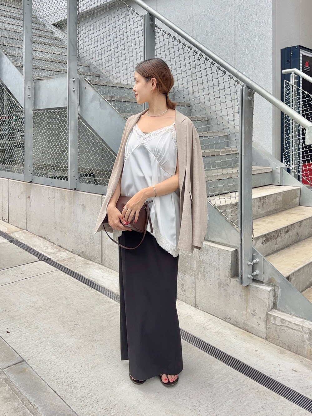 ホワイト系のキャミソール、ブラウン系のショルダーバッグ、ベージュ系のテーラードジャケットを着用したレディースの夏コーディネートの5枚目の写真