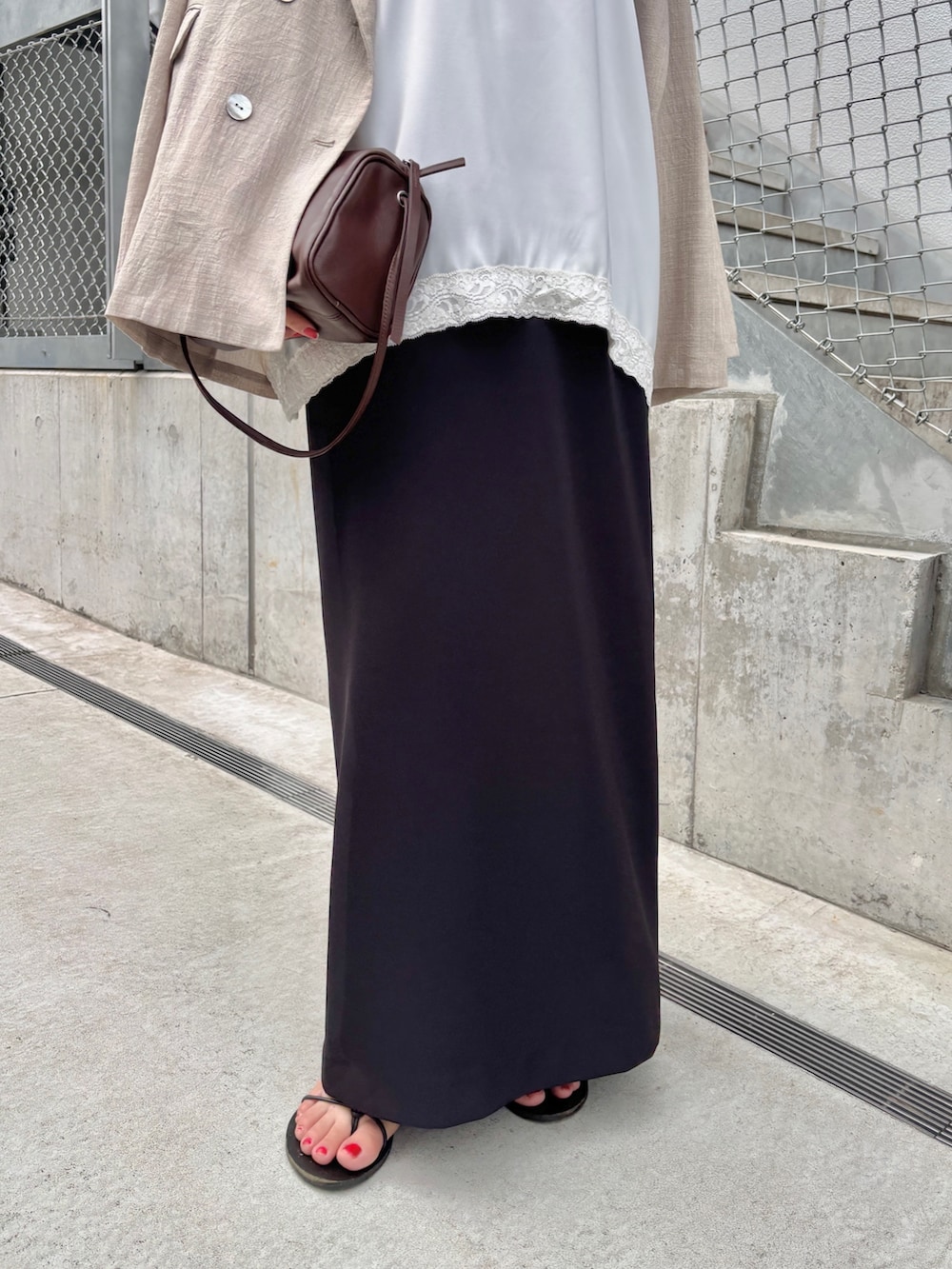 ホワイト系のキャミソール、ブラウン系のショルダーバッグ、ベージュ系のテーラードジャケットを着用したレディースの夏コーディネートの3枚目の写真