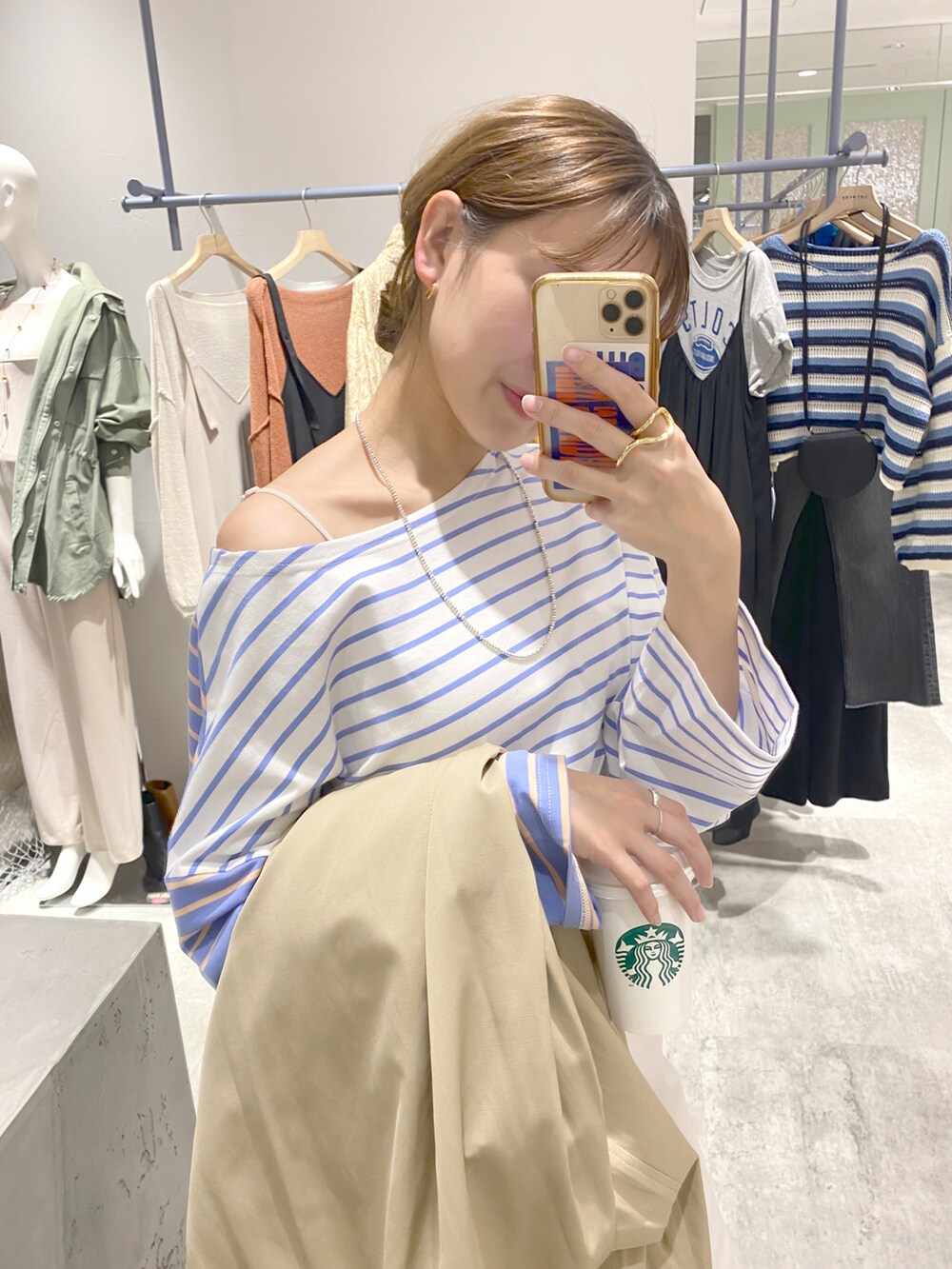 ブルー系のTシャツ/カットソー、ベージュ系のステンカラーコート、グレー系のその他パンツを着用したレディースの春コーディネートの2枚目の写真