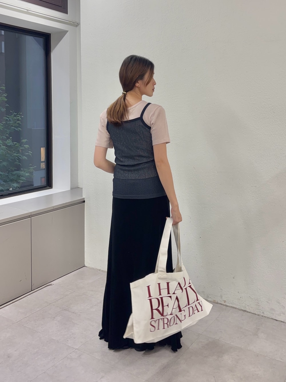 ピンク系のTシャツ/カットソー、ブラック系のスカート、ホワイト系のトートバッグを着用したレディースの夏コーディネートの2枚目の写真