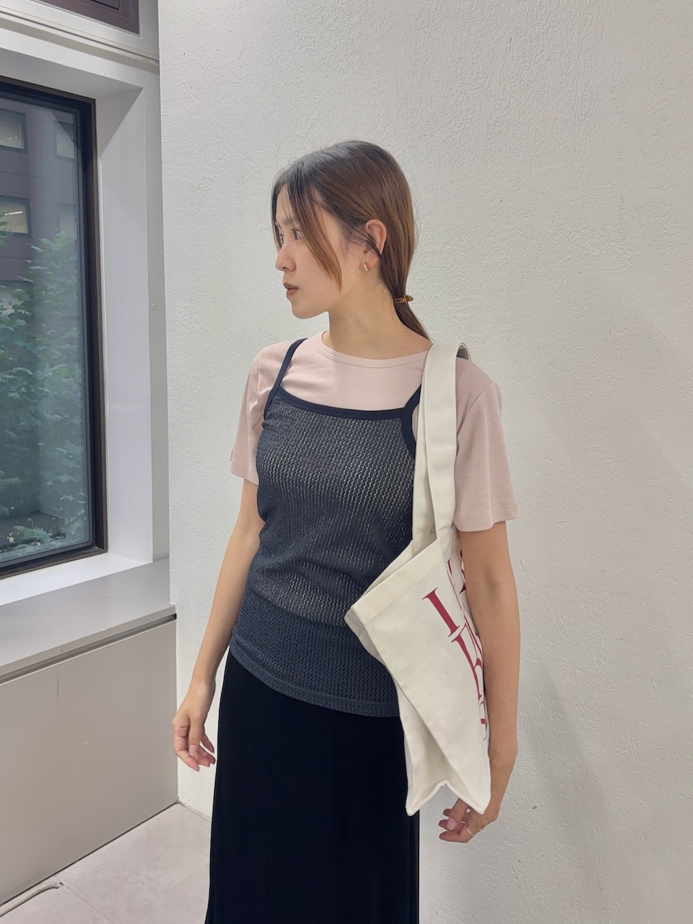 ピンク系のTシャツ/カットソー、ブラック系のスカート、ホワイト系のトートバッグを着用したレディースの夏コーディネートの5枚目の写真