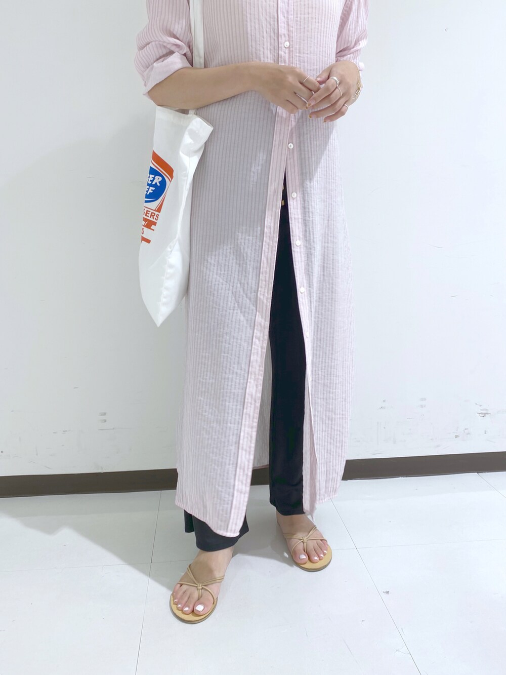 ピンク系のワンピース、ホワイト系のトートバッグ、ブラック系のその他パンツを着用したレディースの秋コーディネートの3枚目の写真