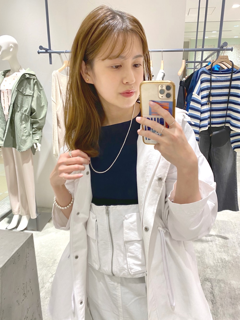 ブルー系のニット/セーター、ホワイト系のブルゾン、ホワイト系のベストを着用したレディースの春コーディネートの3枚目の写真