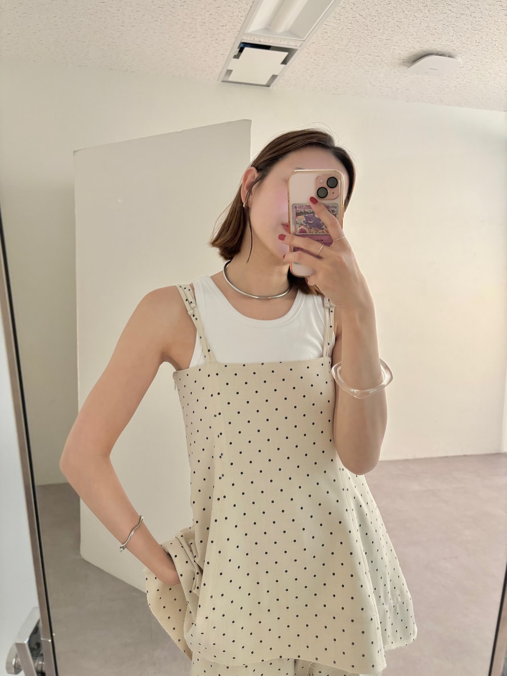 ホワイト系のタンクトップ、ホワイト系のサロペット/オーバーオール、ブラック系のサンダルを着用したレディースの春コーディネートの2枚目の写真