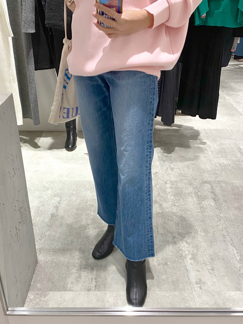 ピンク系のニット/セーター、ブルー系のデニムパンツ、ホワイト系のトートバッグを着用したレディースの冬コーディネートの3枚目の写真