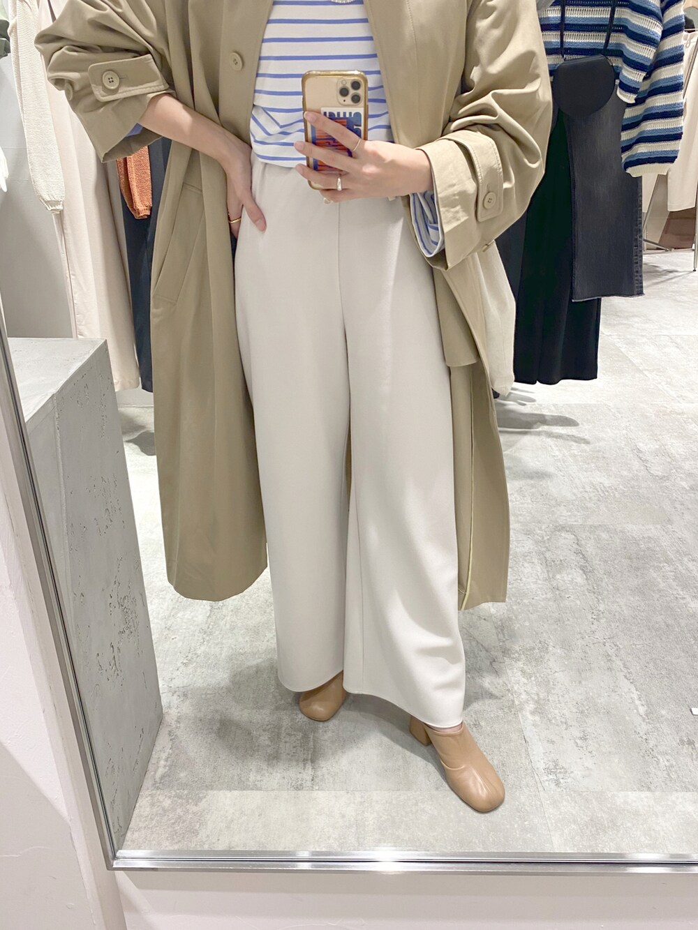 ブルー系のTシャツ/カットソー、ベージュ系のステンカラーコート、グレー系のその他パンツを着用したレディースの春コーディネートの3枚目の写真