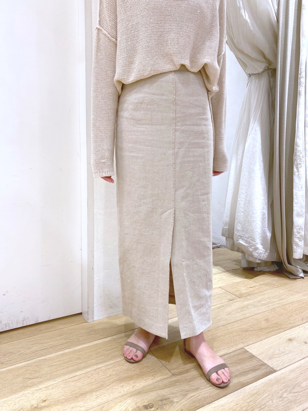 ベージュ系のニット/セーター、ベージュ系のスカート、ベージュ系のサンダルを着用したレディースの春コーディネートの3枚目の写真