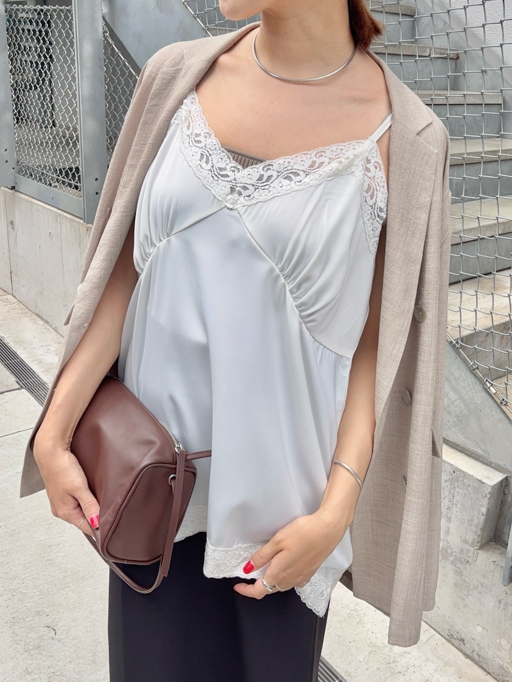 ホワイト系のキャミソール、ブラウン系のショルダーバッグ、ベージュ系のテーラードジャケットを着用したレディースの夏コーディネートの2枚目の写真