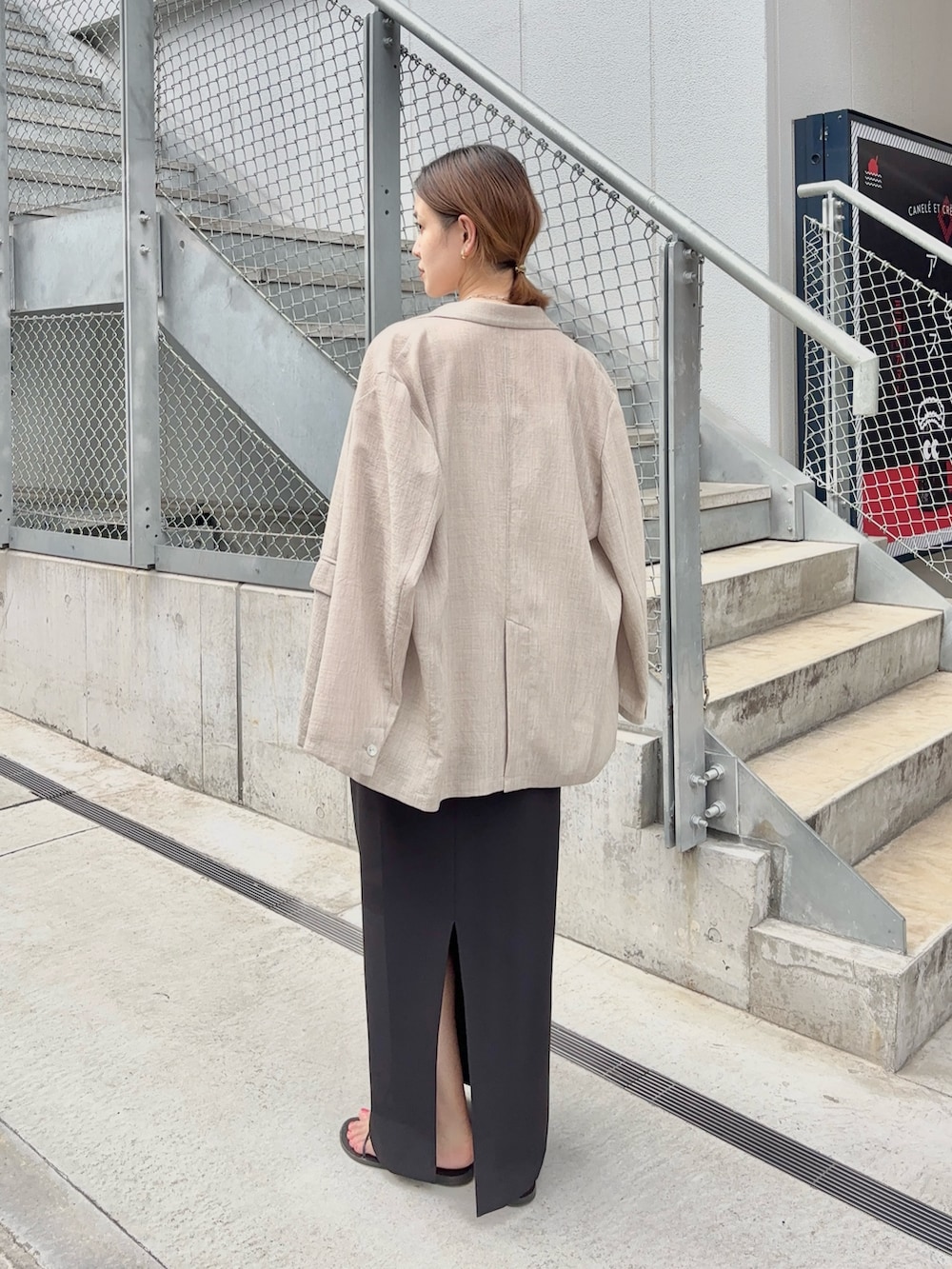 ホワイト系のキャミソール、ブラウン系のショルダーバッグ、ベージュ系のテーラードジャケットを着用したレディースの夏コーディネートの4枚目の写真