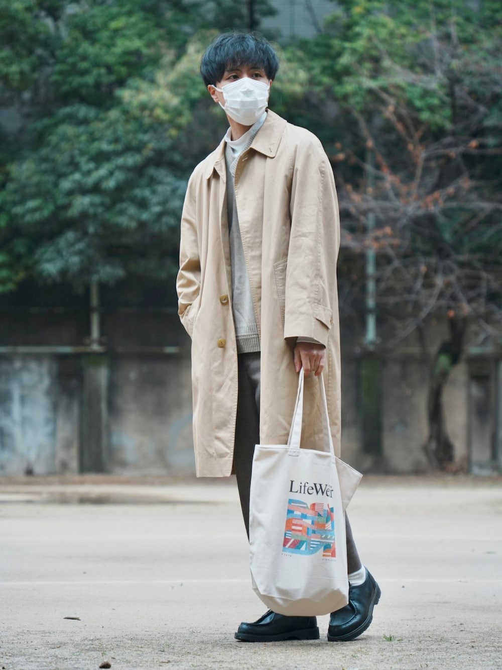 ベージュ系のトートバッグ、ブラック系のモカシン/デッキシューズ、ベージュ系のベストを着用したメンズの冬コーディネートの2枚目の写真