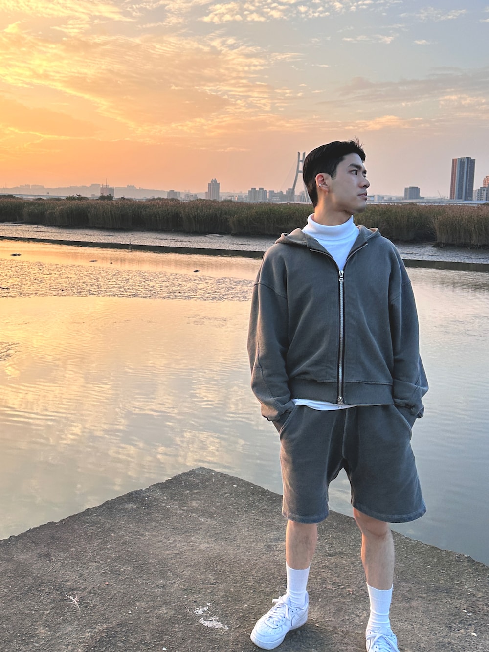 グレー系のパーカー、グレー系のスウェットパンツ、ホワイト系のスニーカーを着用したメンズの春コーディネートの2枚目の写真