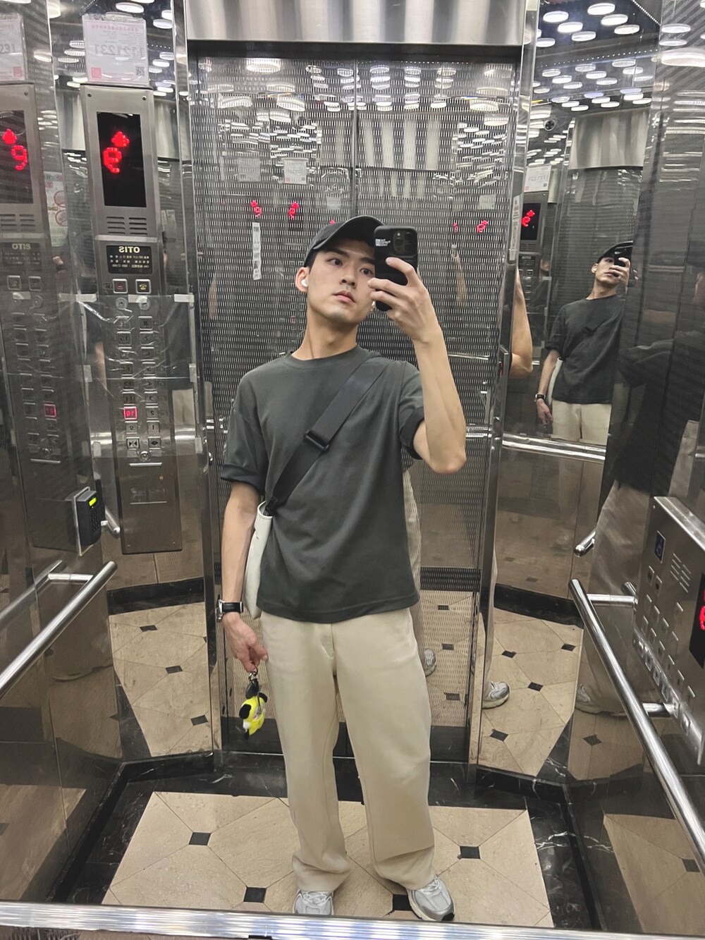 ホワイト系のトートバッグ、シルバー系のスニーカー、ブラック系のスマホケース/カバーを着用したメンズの夏コーディネートの2枚目の写真