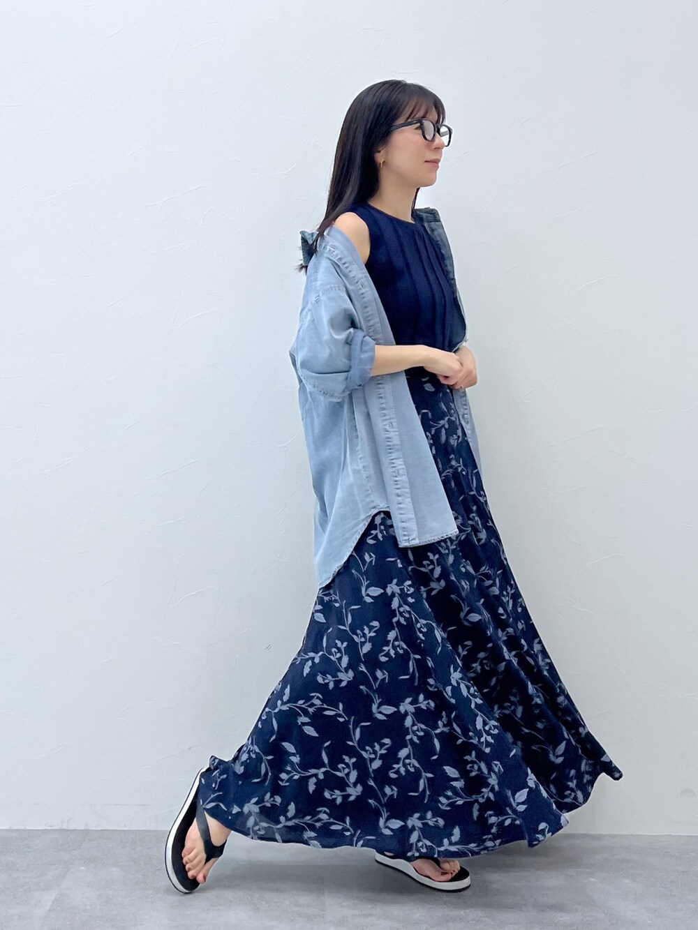 ブルー系のスカート、ブルー系のトップス、ブラック系のサンダルを着用したレディースの春コーディネートの2枚目の写真