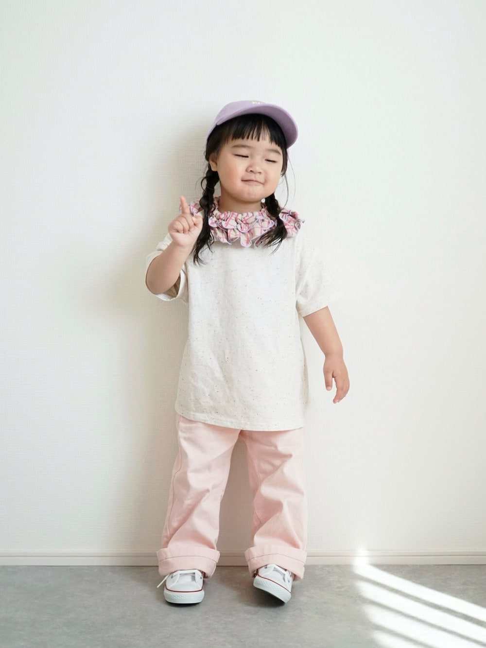 ブルー系のデニムジャケット、ホワイト系のスニーカー、ピンク系のデニムパンツを着用したキッズの春コーディネートの2枚目の写真