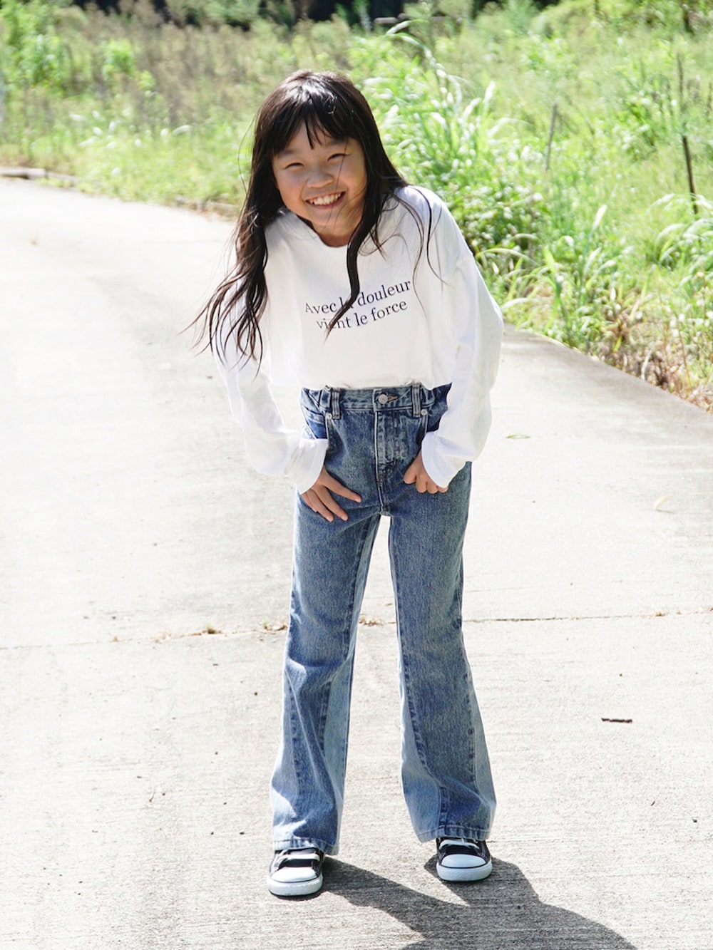 ホワイト系のTシャツ/カットソー、ブルー系のデニムパンツ、ブラック系のスニーカーを着用したキッズの秋コーディネートの2枚目の写真