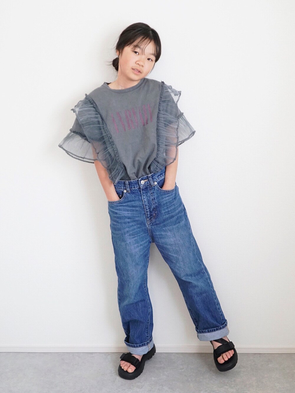 グレー系のTシャツ/カットソー、ブルー系のデニムパンツ、ブラック系のサンダルを着用したキッズの春コーディネートの3枚目の写真