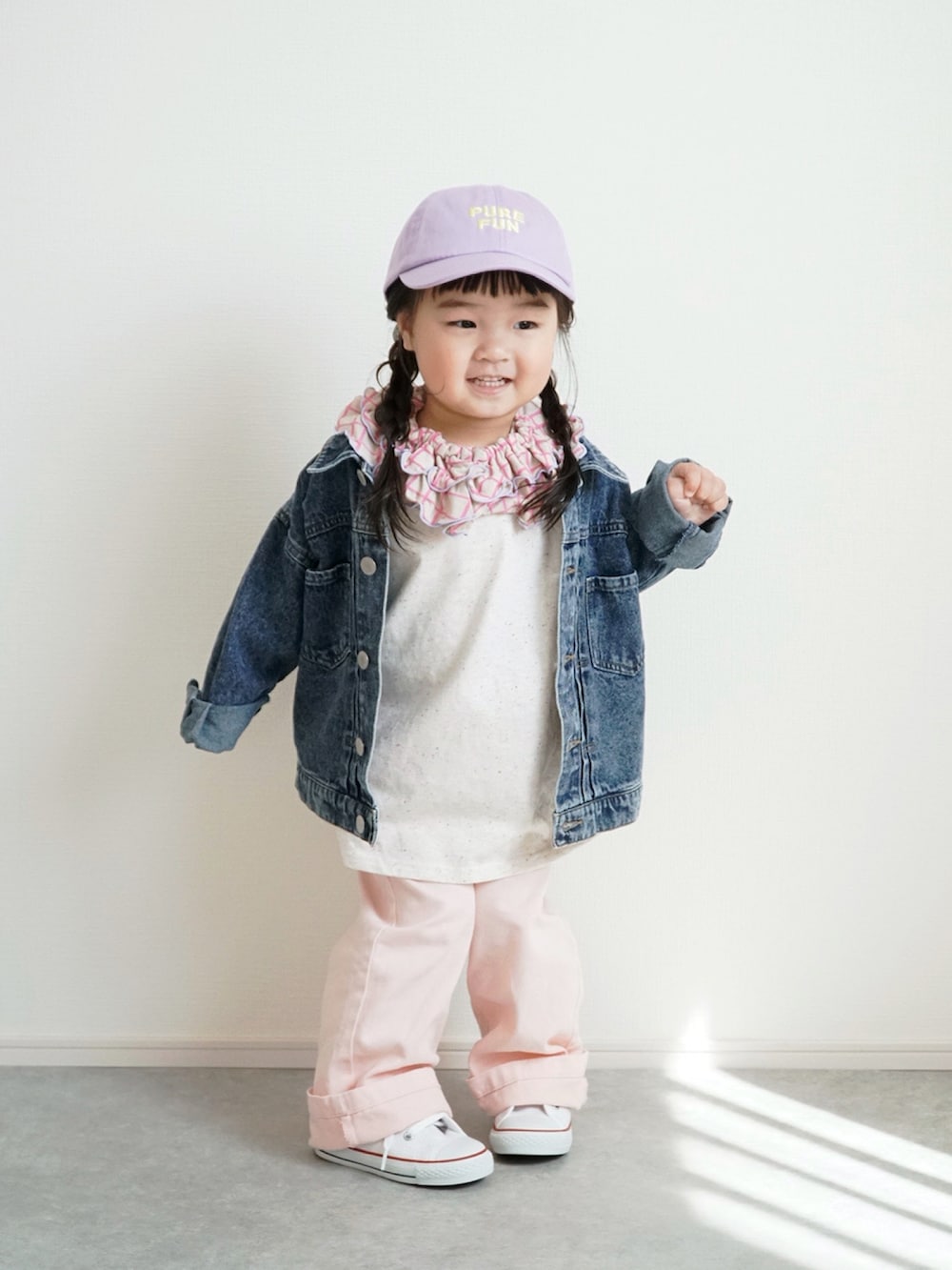 ブルー系のデニムジャケット、ホワイト系のスニーカー、ピンク系のデニムパンツを着用したキッズの春コーディネートの4枚目の写真