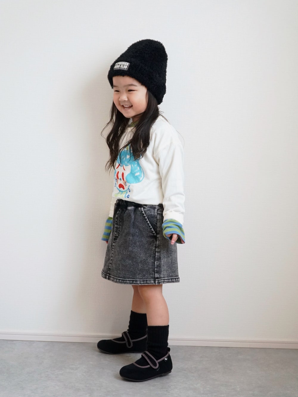 ホワイト系のTシャツ/カットソー、グリーン系のTシャツ/カットソー、ブラック系のデニムパンツを着用したキッズの秋コーディネートの5枚目の写真