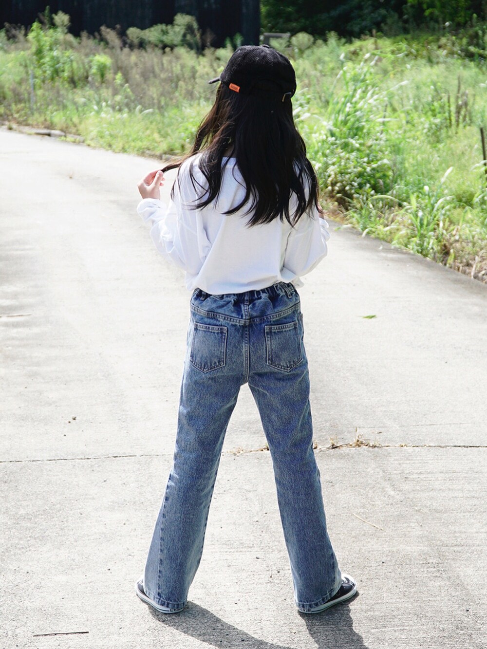 ホワイト系のTシャツ/カットソー、ブルー系のデニムパンツ、ブラック系のスニーカーを着用したキッズの秋コーディネートの4枚目の写真