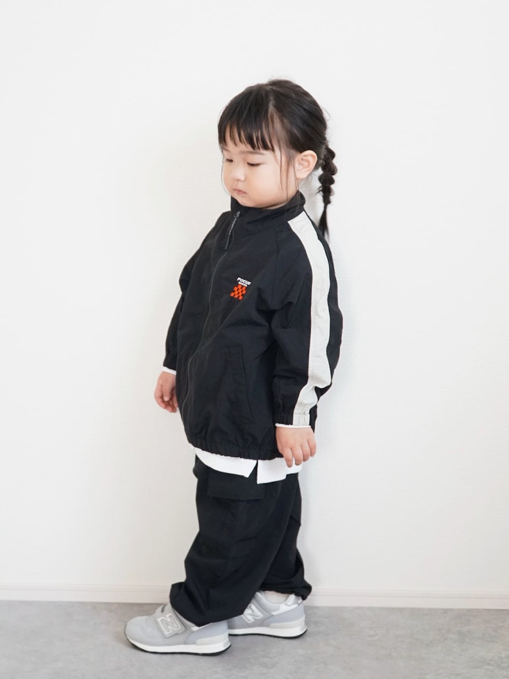 ホワイト系のTシャツ/カットソー、ブラック系のその他アウター、ブラック系のカーゴパンツを着用したキッズの冬コーディネートの3枚目の写真