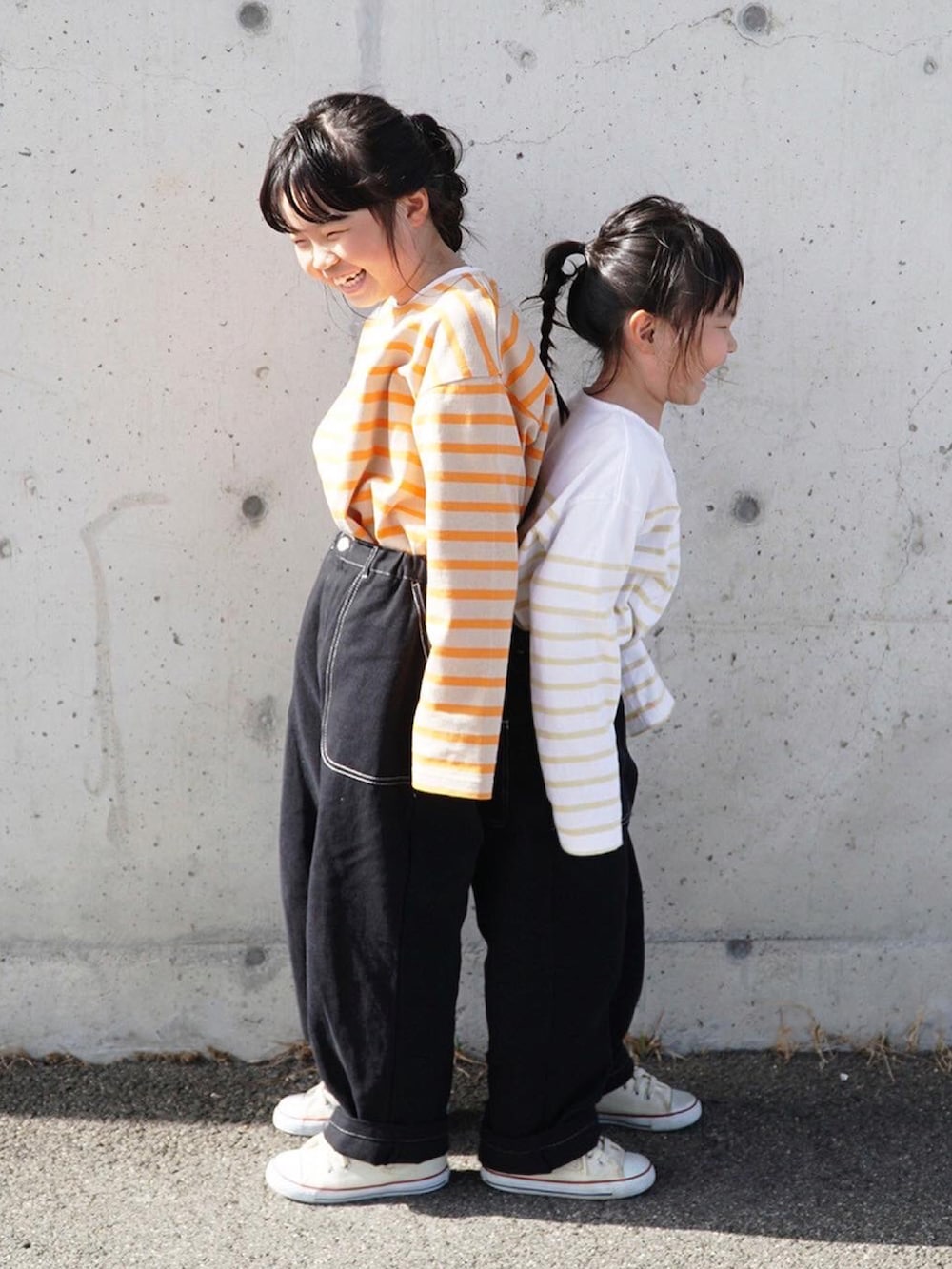 オレンジ系のTシャツ/カットソー、イエロー系のTシャツ/カットソー、ブラック系のその他パンツを着用したキッズの春コーディネートの3枚目の写真