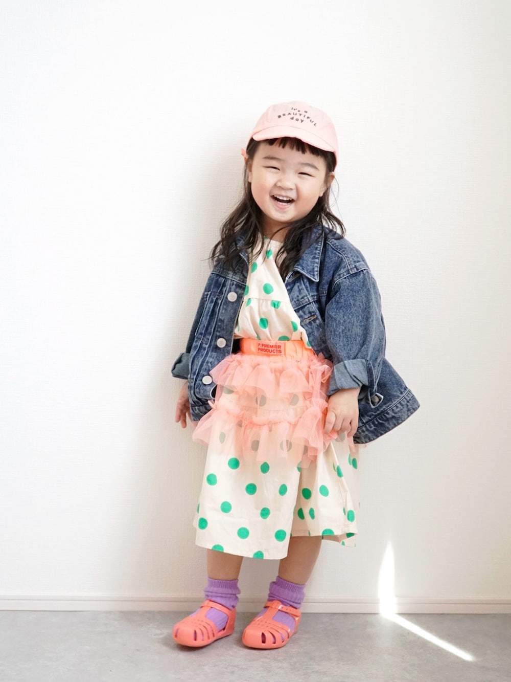 ブルー系のデニムジャケット、ピンク系のスカート、その他のワンピースを着用したキッズの春コーディネートの2枚目の写真