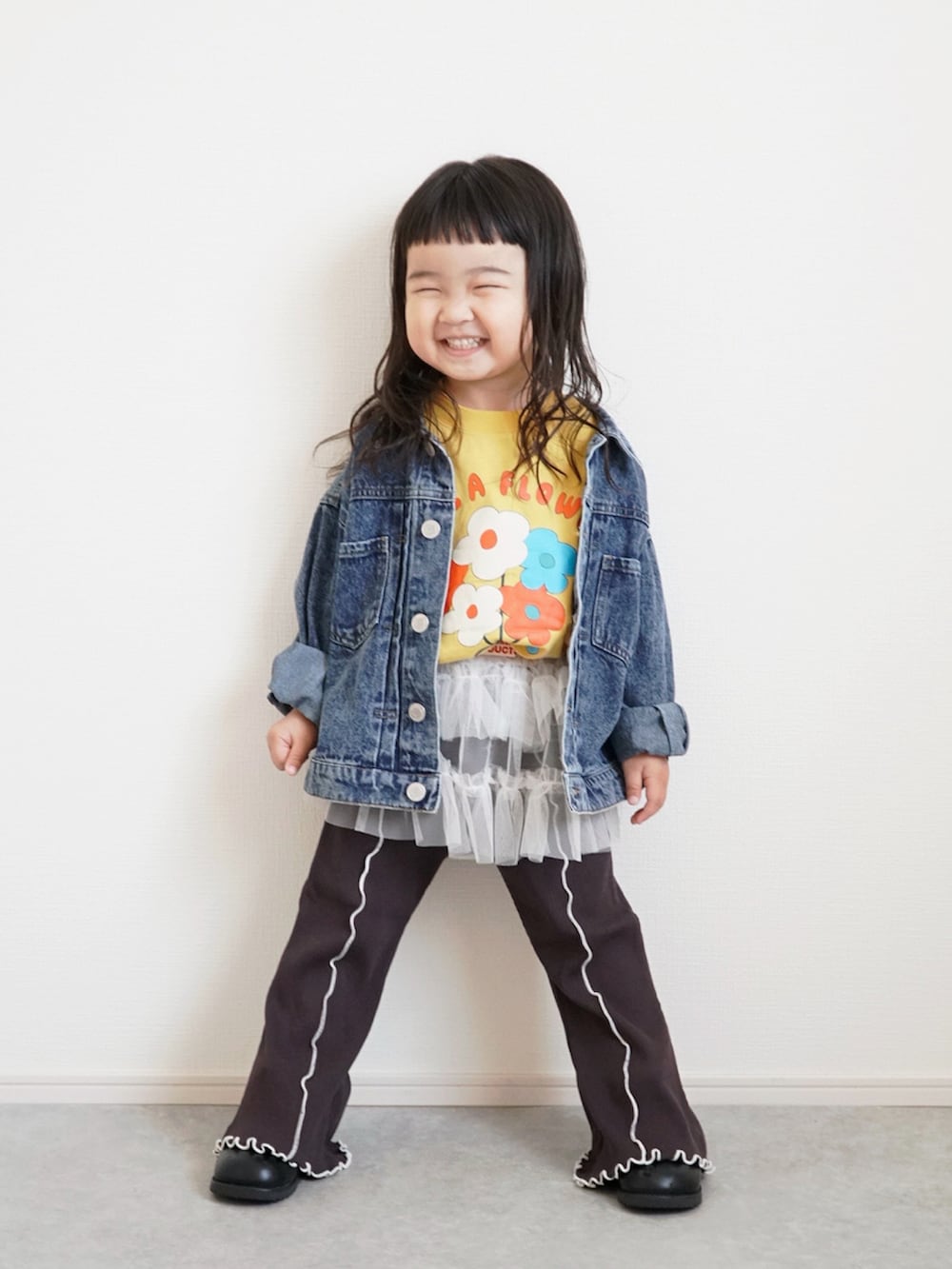 ブラック系のブーツ、イエロー系のTシャツ/カットソー、ブルー系のデニムジャケットを着用したキッズの春コーディネートの2枚目の写真