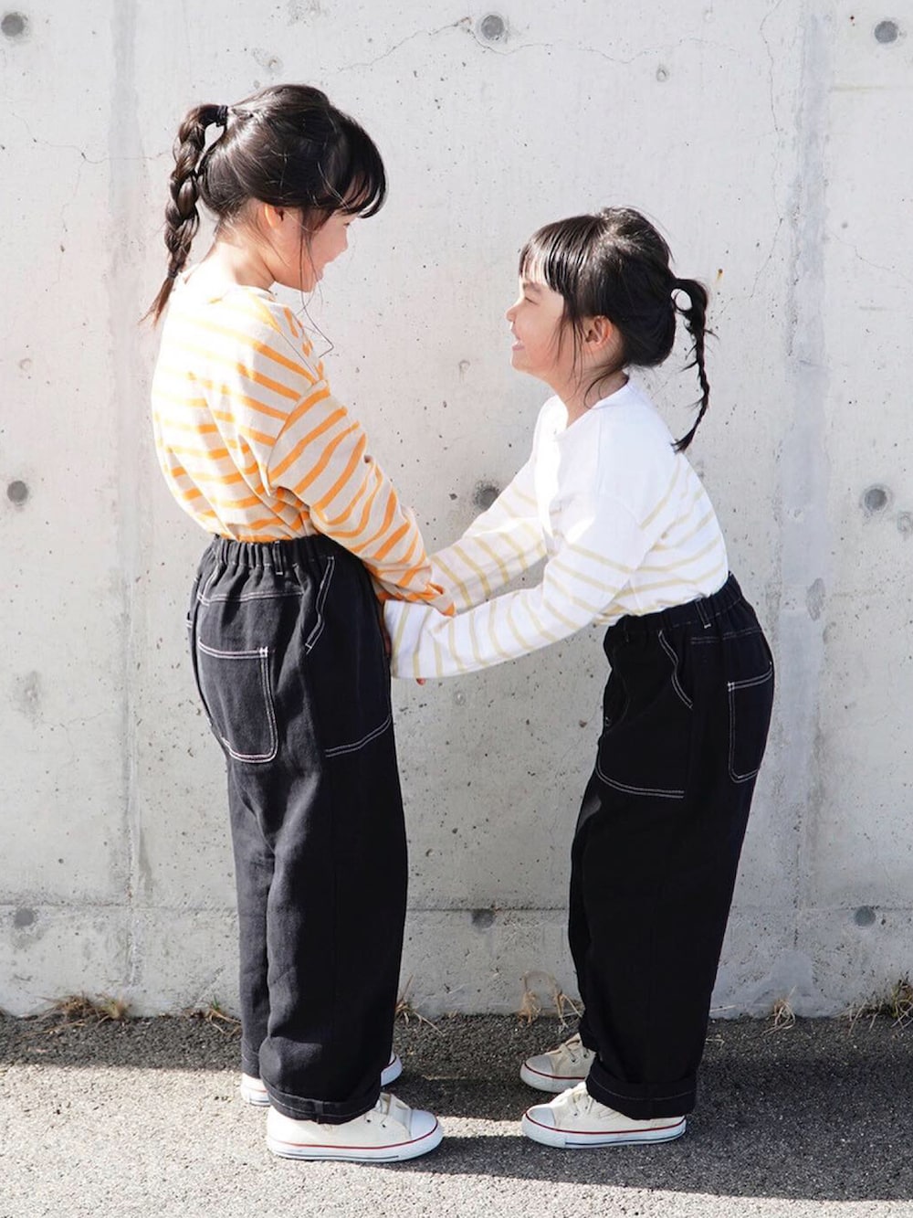 オレンジ系のTシャツ/カットソー、イエロー系のTシャツ/カットソー、ブラック系のその他パンツを着用したキッズの春コーディネートの2枚目の写真