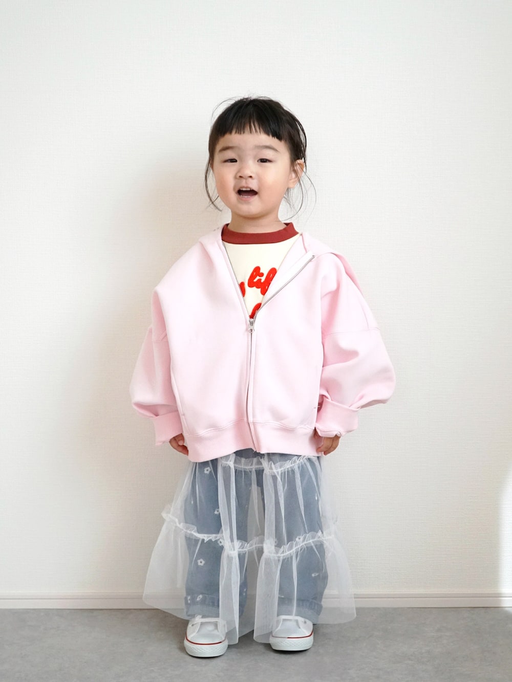 ピンク系のパーカー、ホワイト系のTシャツ/カットソー、ブルー系のデニムパンツを着用したキッズの春コーディネートの2枚目の写真