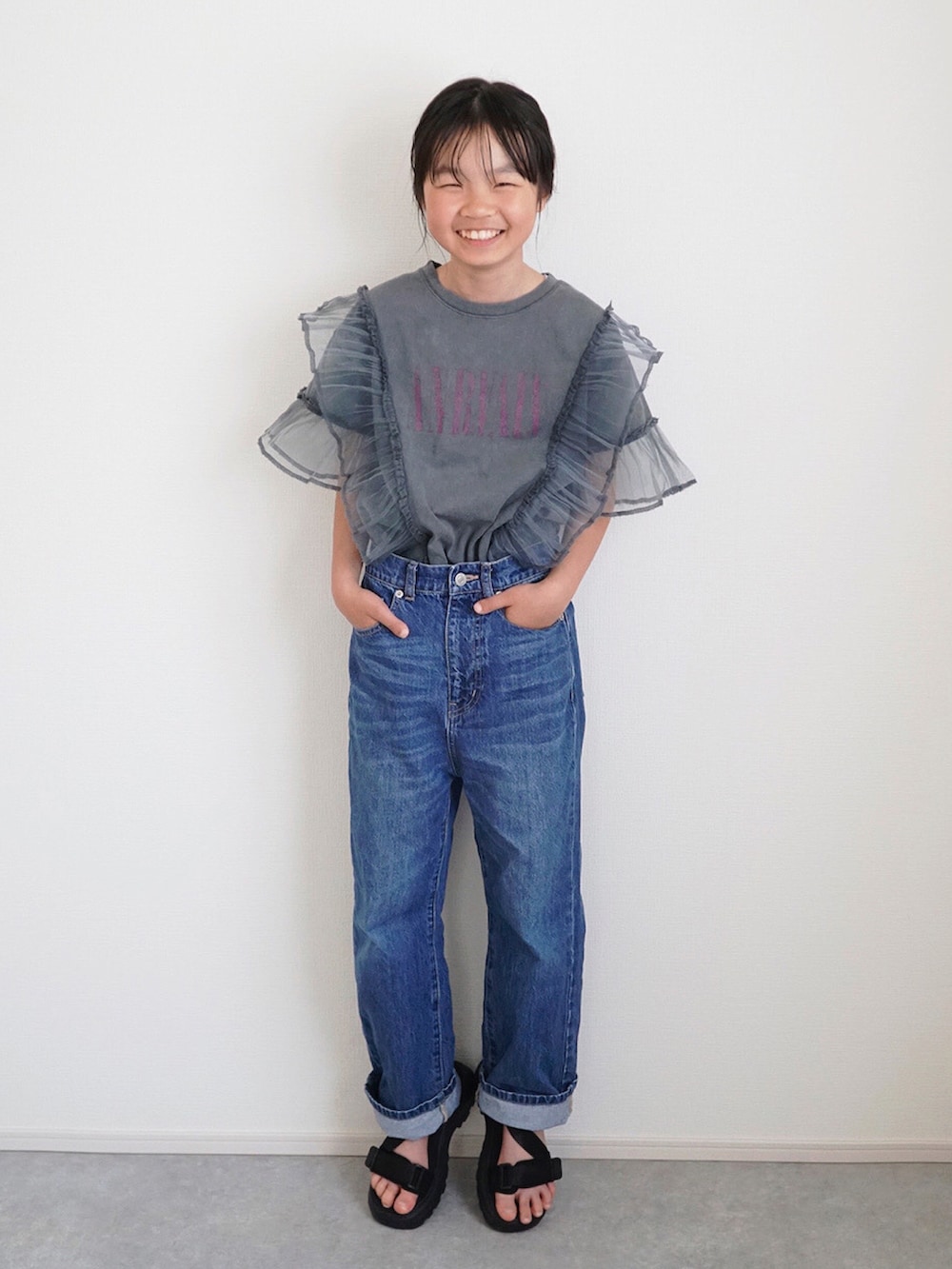グレー系のTシャツ/カットソー、ブルー系のデニムパンツ、ブラック系のサンダルを着用したキッズの春コーディネートの4枚目の写真