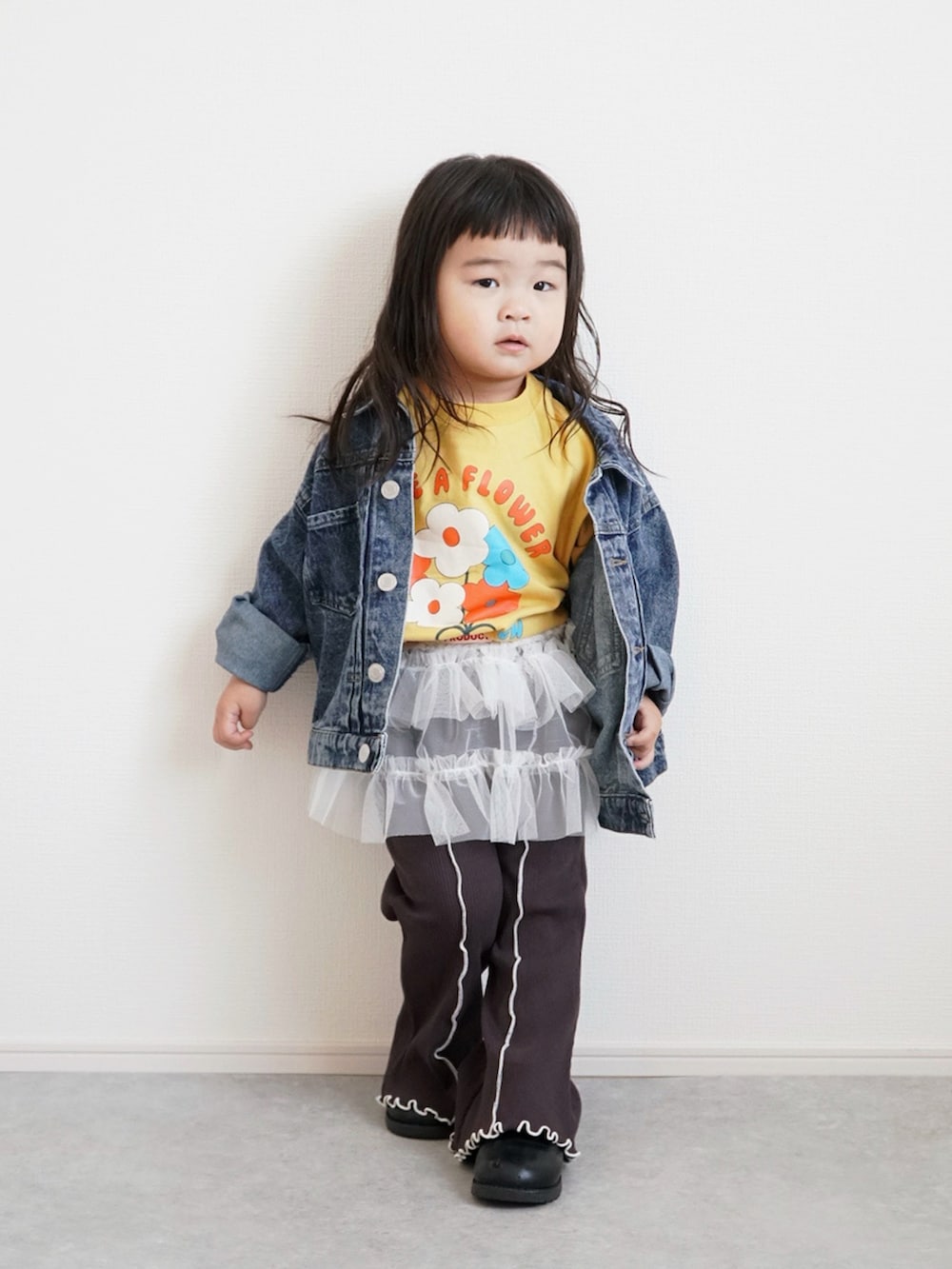 ブラック系のブーツ、イエロー系のTシャツ/カットソー、ブルー系のデニムジャケットを着用したキッズの春コーディネートの3枚目の写真