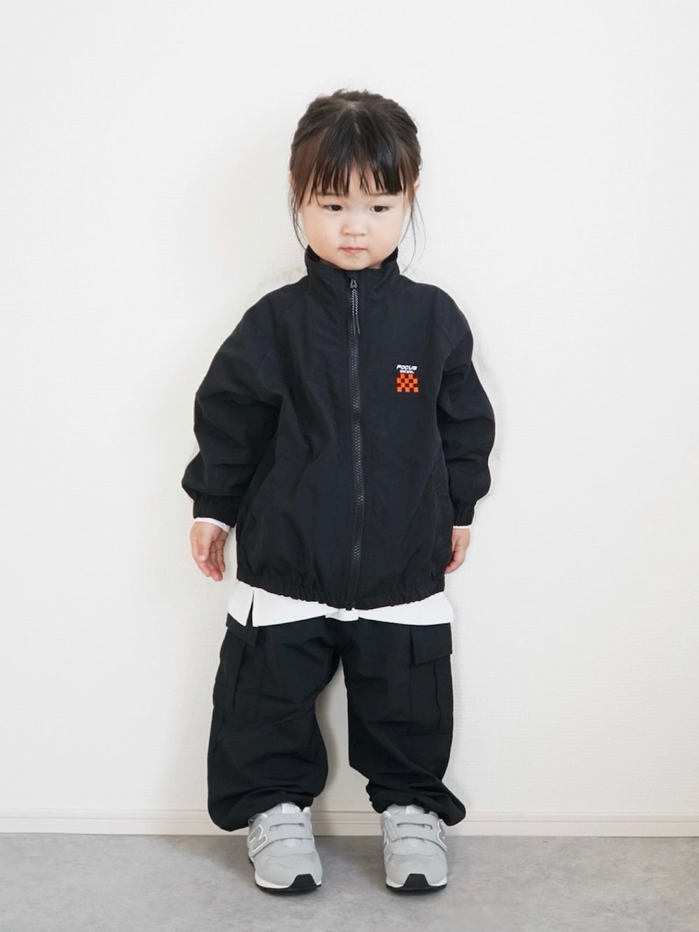 ホワイト系のTシャツ/カットソー、ブラック系のその他アウター、ブラック系のカーゴパンツを着用したキッズの冬コーディネートの2枚目の写真