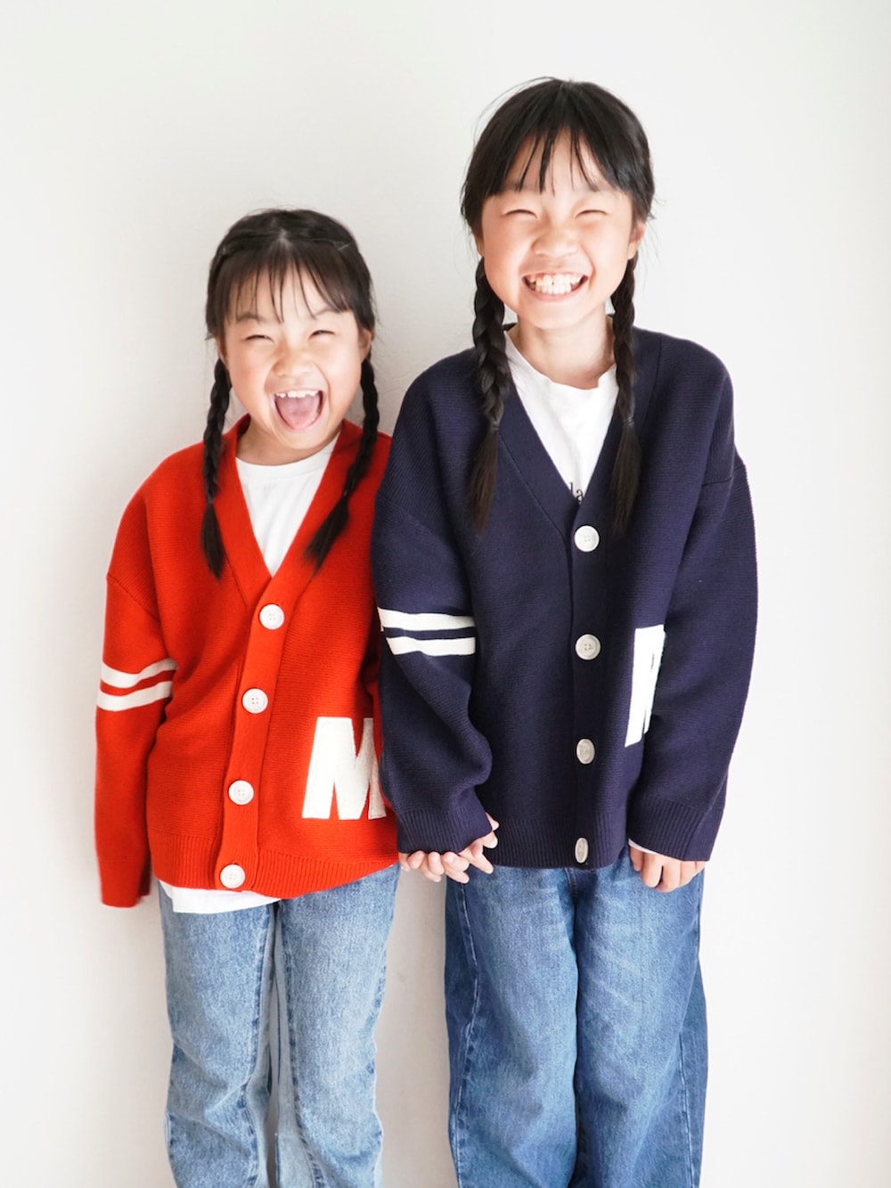 ブルー系のニット/セーター、レッド系のニット/セーター、ブルー系のデニムパンツを着用したキッズの秋コーディネートの3枚目の写真