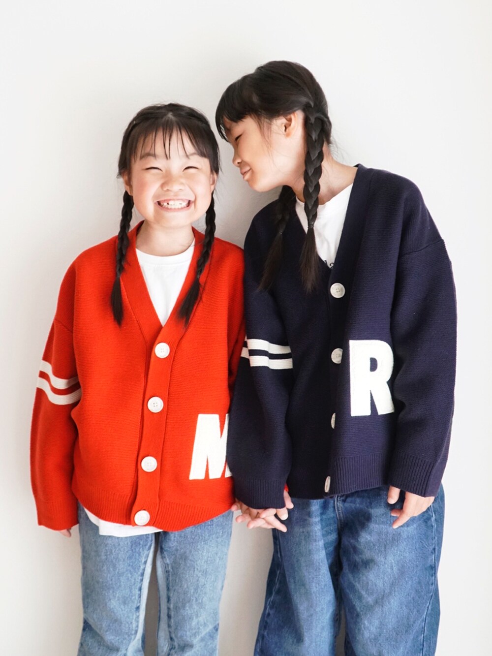 ブルー系のニット/セーター、レッド系のニット/セーター、ブルー系のデニムパンツを着用したキッズの秋コーディネートの4枚目の写真