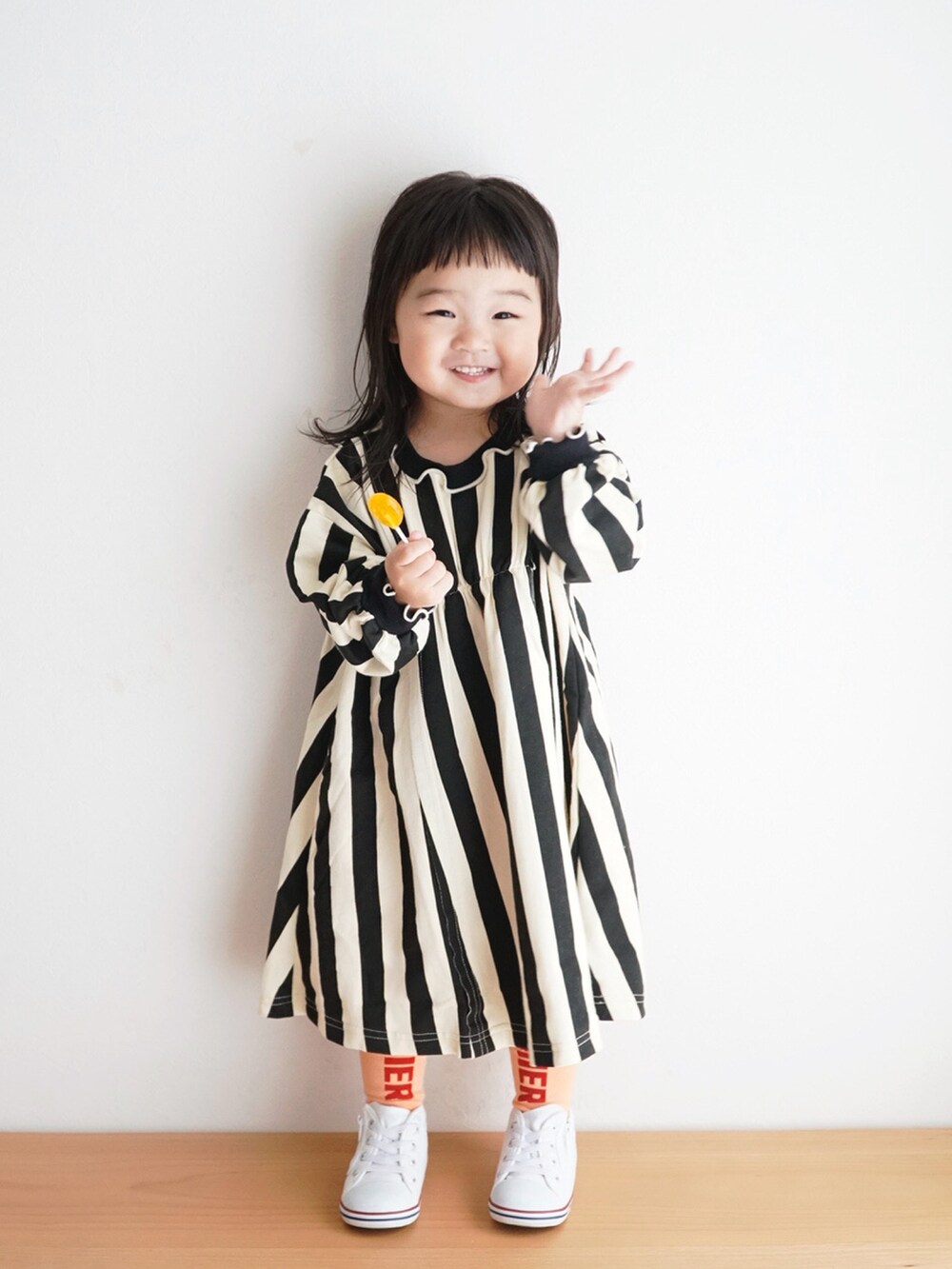 ホワイト系のスニーカー、ブラック系のワンピース、オレンジ系のタイツ/ストッキングを着用したキッズの秋コーディネートの4枚目の写真