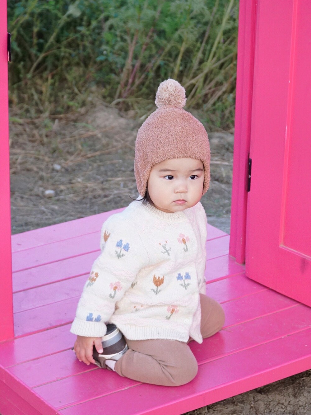 ホワイト系のカーディガン/ボレロ、ブラウン系のスニーカー、ベージュ系のニットキャップ/ビーニーを着用したキッズの秋コーディネートの2枚目の写真