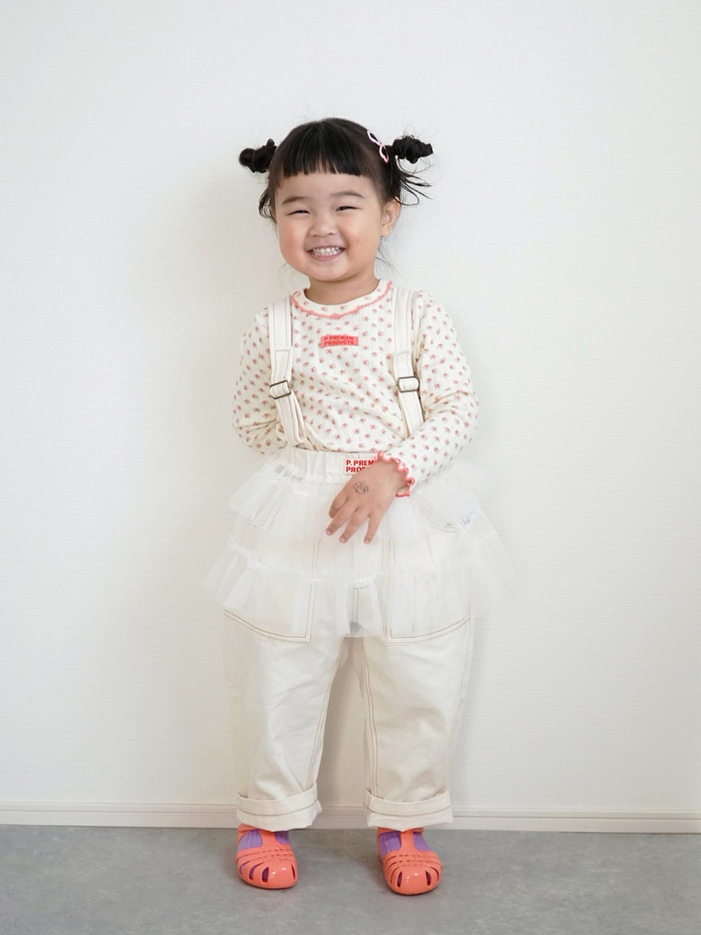 ピンク系のTシャツ/カットソー、ホワイト系のデニムパンツ、ホワイト系のスカートを着用したキッズの春コーディネートの3枚目の写真