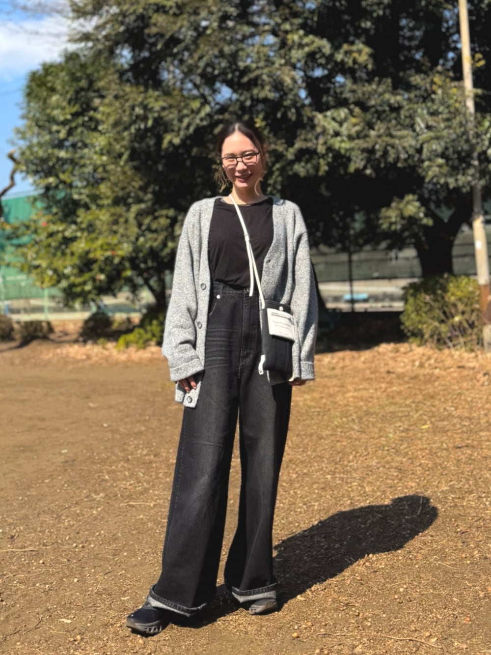 グレー系のカーディガン/ボレロ、ブラック系のショルダーバッグ、ブラック系のサロペット/オーバーオールを着用したレディースの春コーディネートの4枚目の写真