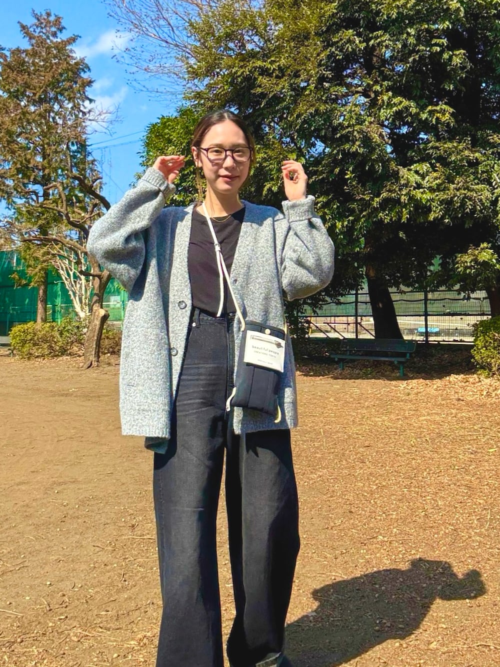 グレー系のカーディガン/ボレロ、ブラック系のショルダーバッグ、ブラック系のサロペット/オーバーオールを着用したレディースの春コーディネートの2枚目の写真