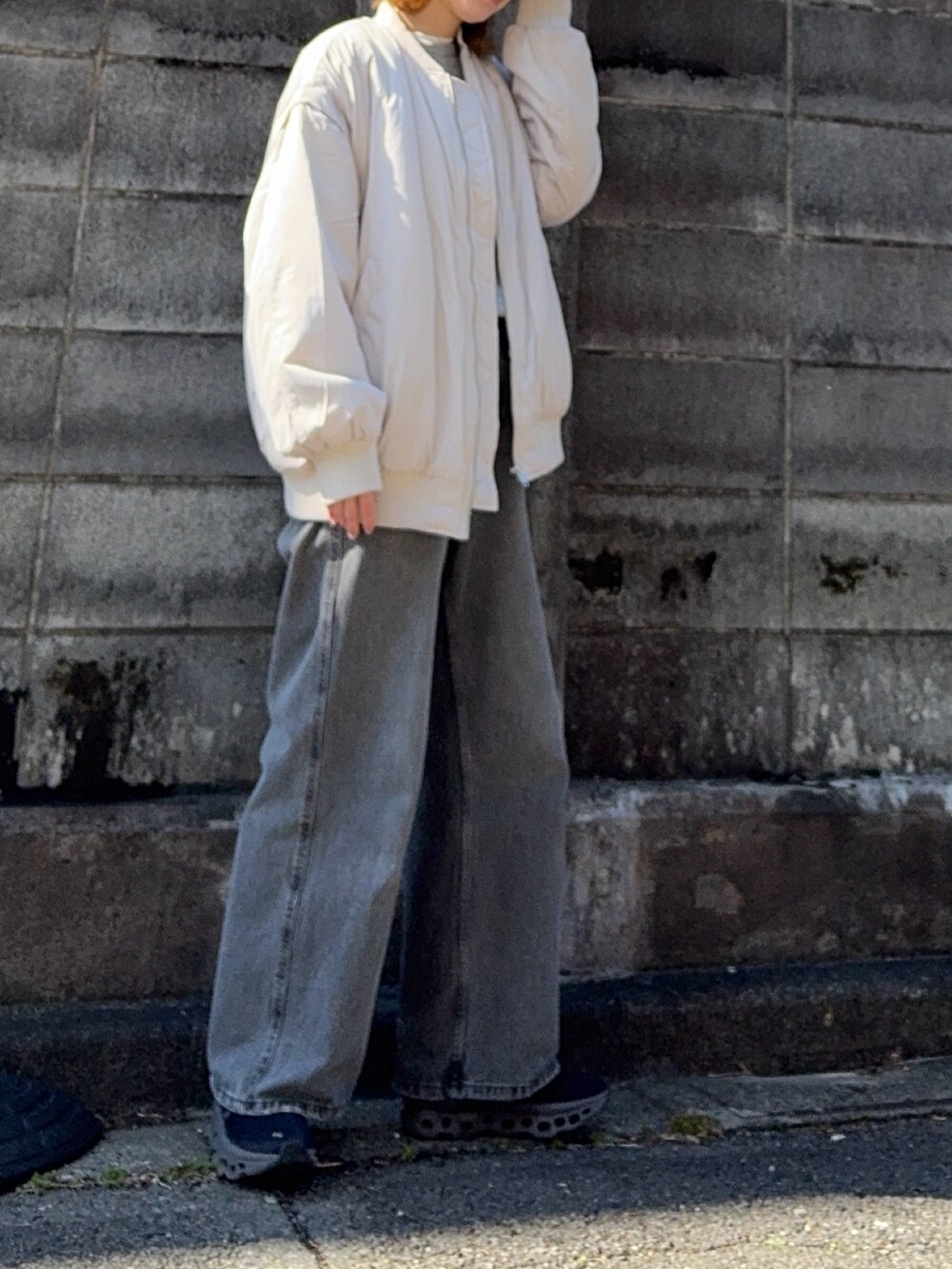 グレー系のデニムパンツ、グレー系のスウェット、ブラック系のスニーカーを着用したレディースの春コーディネートの2枚目の写真