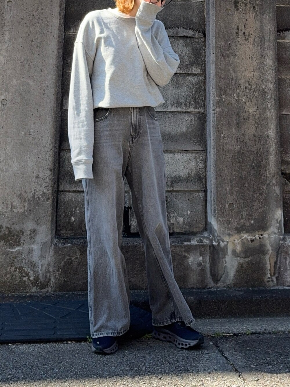 グレー系のデニムパンツ、グレー系のスウェット、ブラック系のスニーカーを着用したレディースの春コーディネートの3枚目の写真