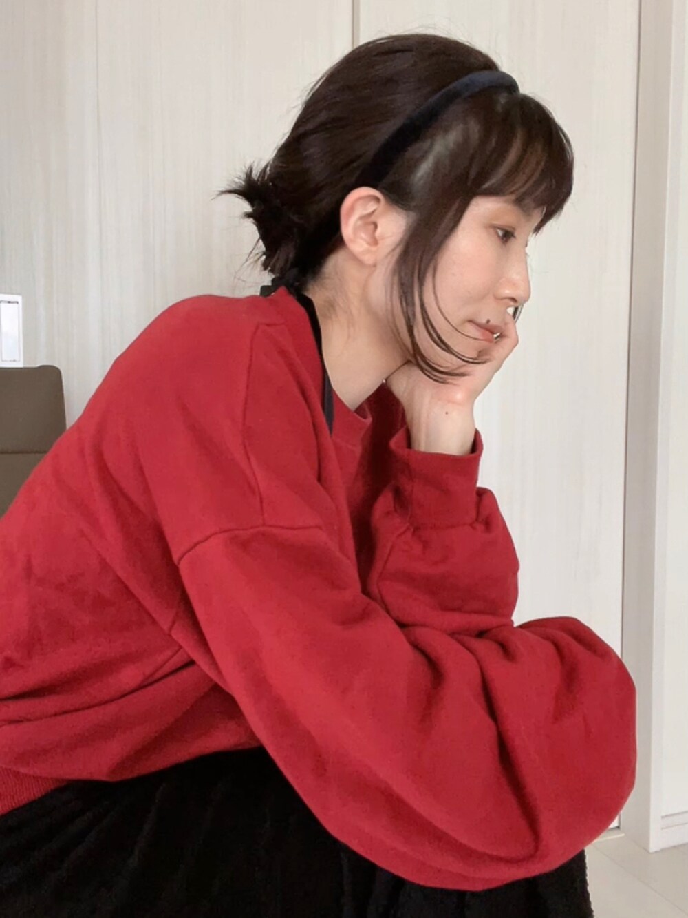 ブラック系のスカート、レッド系のスウェット、ブラック系のサンダルを着用したレディースの夏コーディネートの4枚目の写真