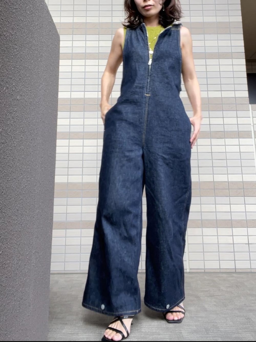 ブラック系のサンダル、ブルー系のつなぎ/オールインワン、グリーン系のニット/セーターを着用したレディースの秋コーディネートの2枚目の写真