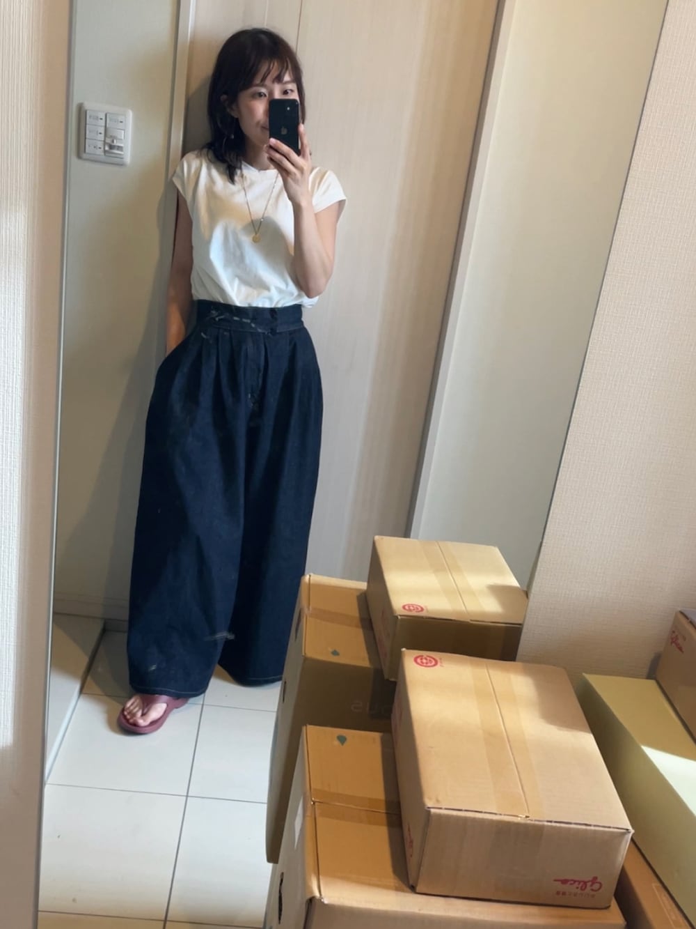 ホワイト系のその他トップス、ブルー系のデニムパンツ、レッド系のサンダルを着用したレディースの夏コーディネートの3枚目の写真