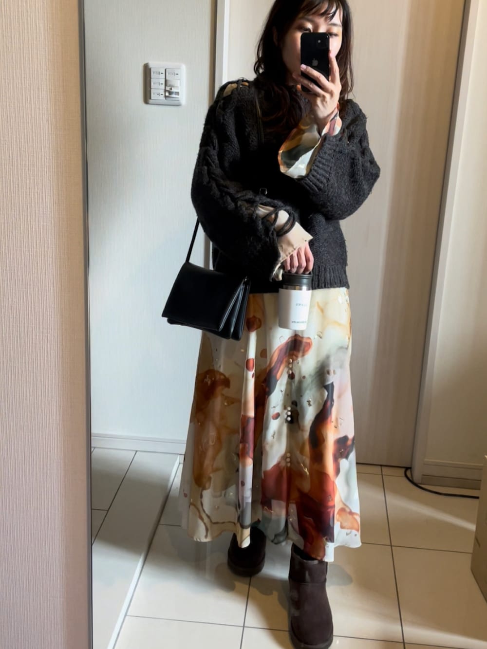 ブラック系のショルダーバッグ、ブラウン系のブーツ、その他のワンピースを着用したレディースの冬コーディネートの2枚目の写真