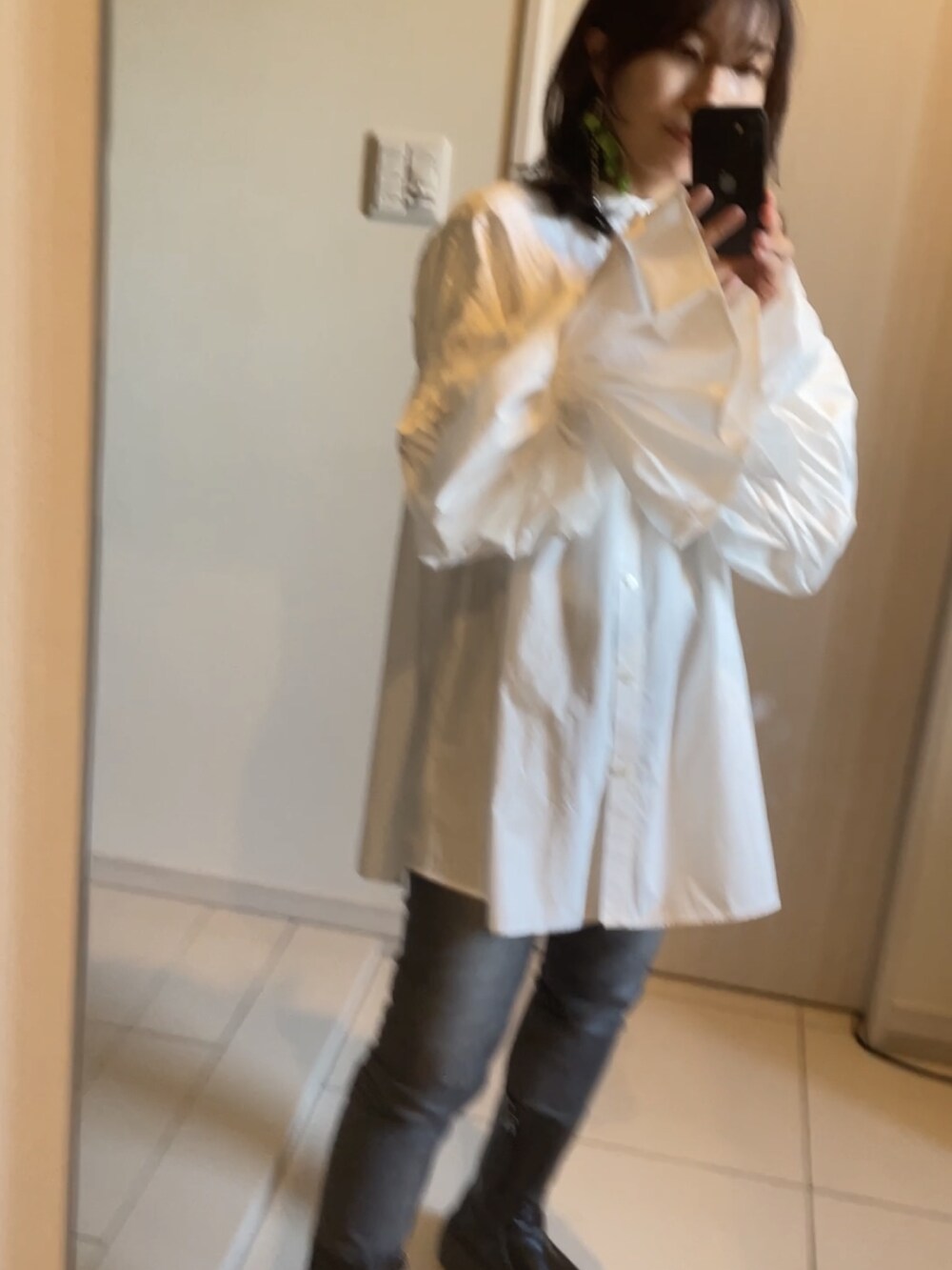 ホワイト系のシャツ/ブラウス、ブラック系のブーツ、グレー系のデニムパンツを着用したレディースの秋コーディネートの3枚目の写真