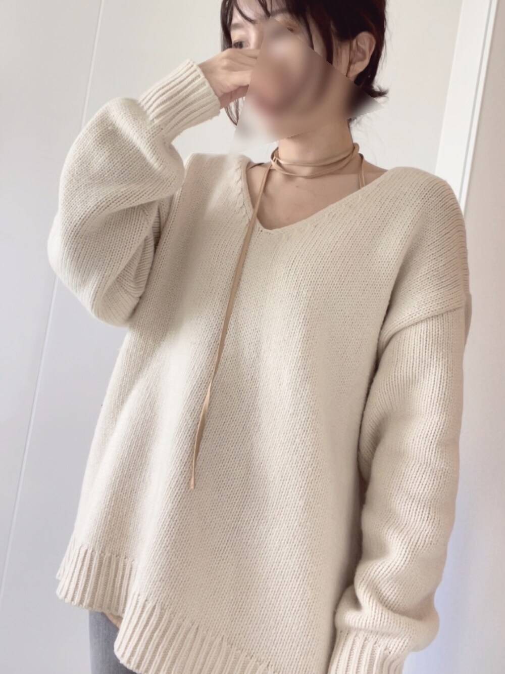 ホワイト系のニット/セーター、ベージュ系のキャミソールを着用したレディースの春コーディネートの2枚目の写真