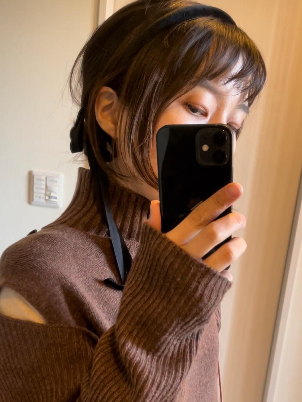 ブラック系のブーツ、ブラウン系のワンピース、ブラウン系のワンピースを着用したレディースの冬コーディネートの2枚目の写真